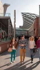 Liverpool One shopping centre. A man and woman, a young couple walking up the ramp outside the new shopping centre development and regeneration in the city.