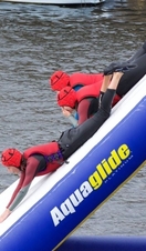 People sliding down a slide into the water at Liverpool Watersports Centre