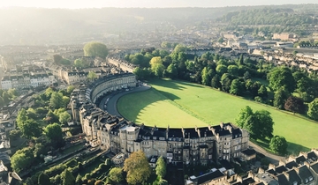 Aerial view of crescent-shaped building surrounded by grass