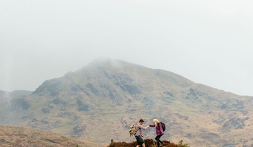 Couple hiking in the mountains on a cloudy day