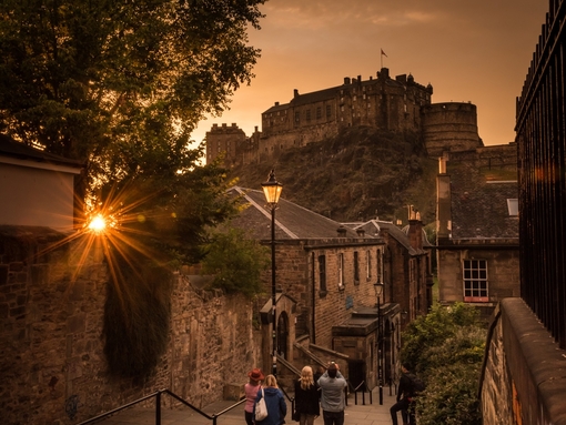Pedestrians walking down steps near a castle