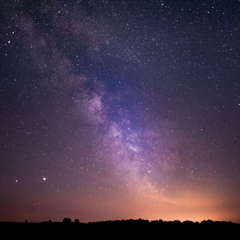 Stars and the Milky Way clearly visible in the night sky.