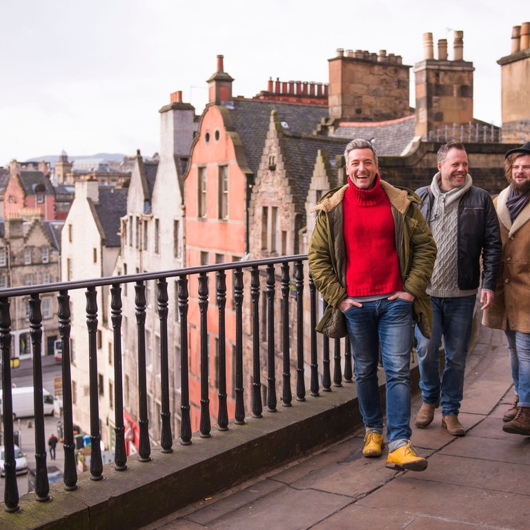 Group of men walking, talking and laughing in city centre