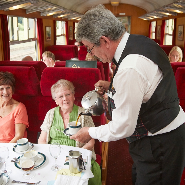 On board staff serving coffee on the Pullman Dining Train.