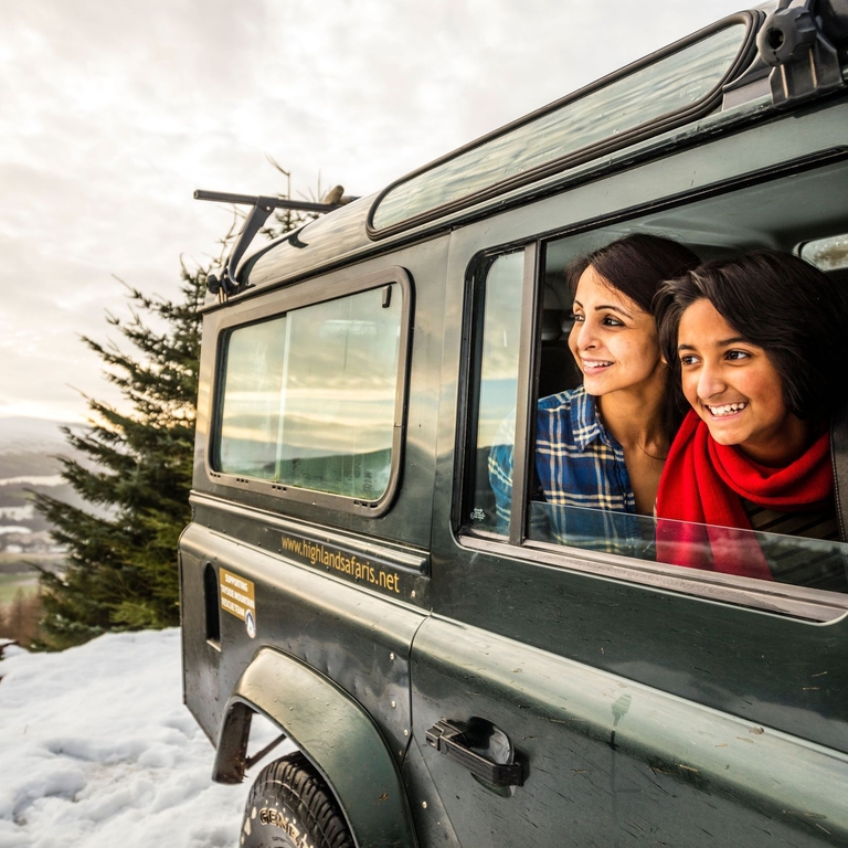 A family in a jeep on snow looking over the landscape