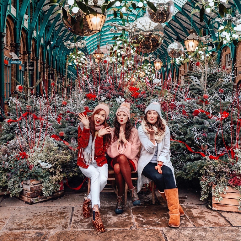 Primer plano de un grupo de amigos riendo y admirando las luces de Navidad