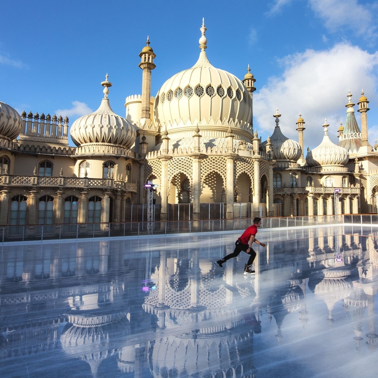 Ice skater with red t-shirt on rink outside Royal Pavilion