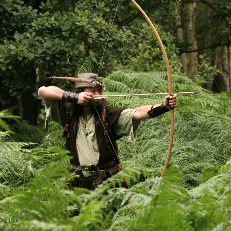 Ein als Robin Hood verkleideter Mann im Sherwood Forest, England