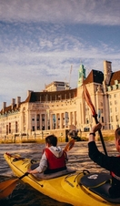 Dos personas navegando en kayak por el Támesis en dirección al London Eye