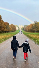A couple walking towards Windsor Castle on the Long Walk in the Great Park