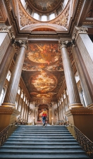 Man walking up a staircase. Painted night sky on ceiling