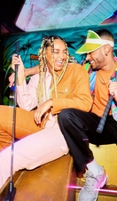 Two people posing with golf clubs at Junkyard Golf in Oxford