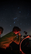Child stargazing through telescope