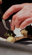 A pair of hands preparing food at Silo in Hackney, London