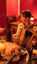 Musicians playing music in a pub. Two violins