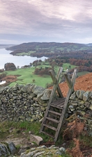 Stile over a drystone wall overlooking landscape of valleys