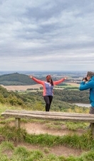 Gente de pie junto a un banco en una ladera, North York Moors, Inglaterra