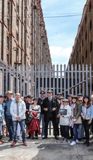 A Peaky Blinders tour group posing outside an industrial warehouse in Liverpool