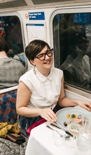 Un grupo de personas cenando en el Supper Club Tube, un restaurante gourmet construido en un tren subterráneo