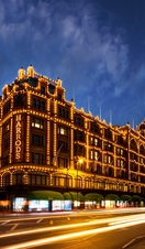 Harrods department store lit up at night. Dark skies