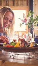 Blond woman and man sitting at table, eating seafood platter