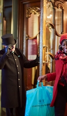 Woman exiting building carrying shopping bags