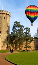 A hot air balloon floats over Warwick Castle in Warwickshire, England.