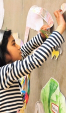 A group of children attaching drawings to a wall at the Nottingham Contemporary Art Gallery