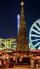A night view to Hyde Park Winter Wonderland lit up with people milling around the market