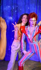 Gäste posieren für ein Foto mit einer David Bowie-Figur im Madame Tussauds London