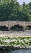 People walking across a bridge in Abbey Park, Leicester