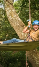 Man hanging from trees in hammock