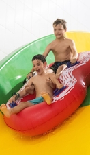 Two children sliding on a pool inflatable at The Wave in Coventry