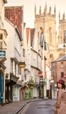Mujer con gabardina y sombrero rosa paseando