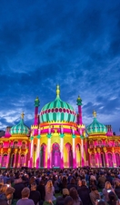 Royal Pavilion at dusk, lit up in a range of vivid colours