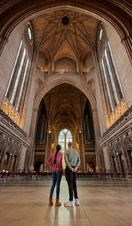 Two people take a tour of an Anglican Cathedral.