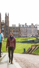 Three men walking on steps beside large columns