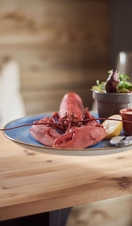 Close up of person holding plate with whole lobster