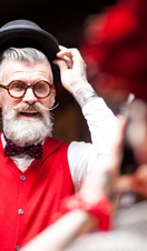 Quirky vintage man photographing boyfriend trying on bowler hat in antiques emporium
