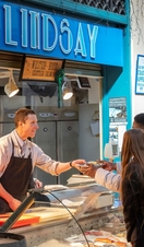 A fishmonger serving a customer at Grainger Market in Newcastle