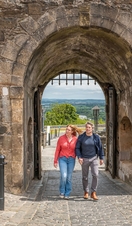 A couple exploring the grounds of a medieval castle.