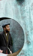 Couple in the gardens examining sculptures with a guidebook