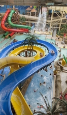 People riding slides at an indoor water park.