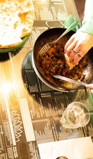 Woman sitting at table eating a curry