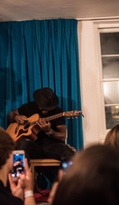 Ein Mann spielt Gitarre vor Publikum im Handel and Hendrix