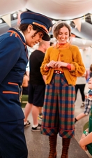 Des acteurs en costume s'adressent à un jeune enfant.