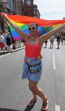 Mujer ondeando la bandera arco iris durante un acto del Orgullo