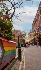 Pedestrians walking along a canal side shopping precinct.