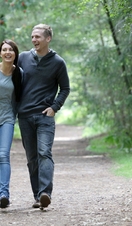 Two people walking along a path in Thetford Forest