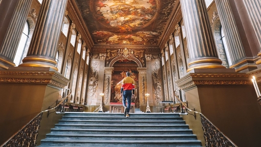 Man walking up a staircase. Painted night sky on ceiling